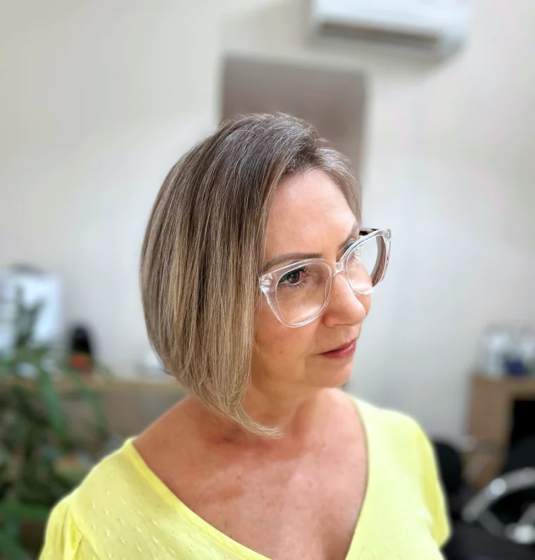 coupe asymetrique femme 50 ans avec des lunettes montures transparentes top jaune