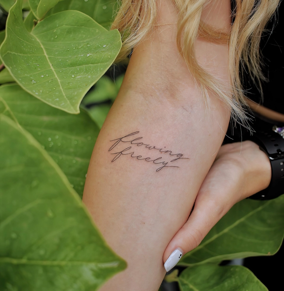 feuilles vertes plante manucure blanche montre tatouage lettres bras