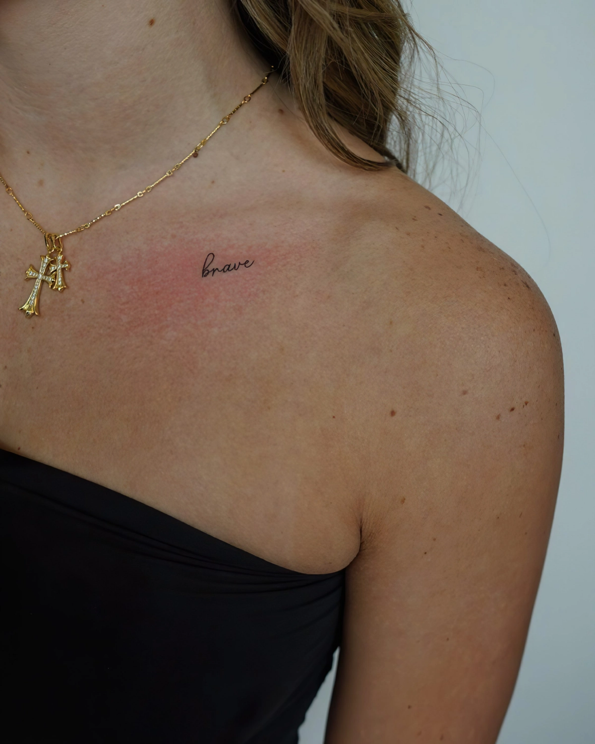 petit tatouage femme sur clavicule bijou collier en or cheveux long
