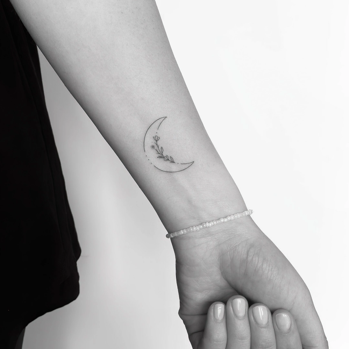 photo blanc noir tatouage minimaliste motif lune croissant fleurs bracelet