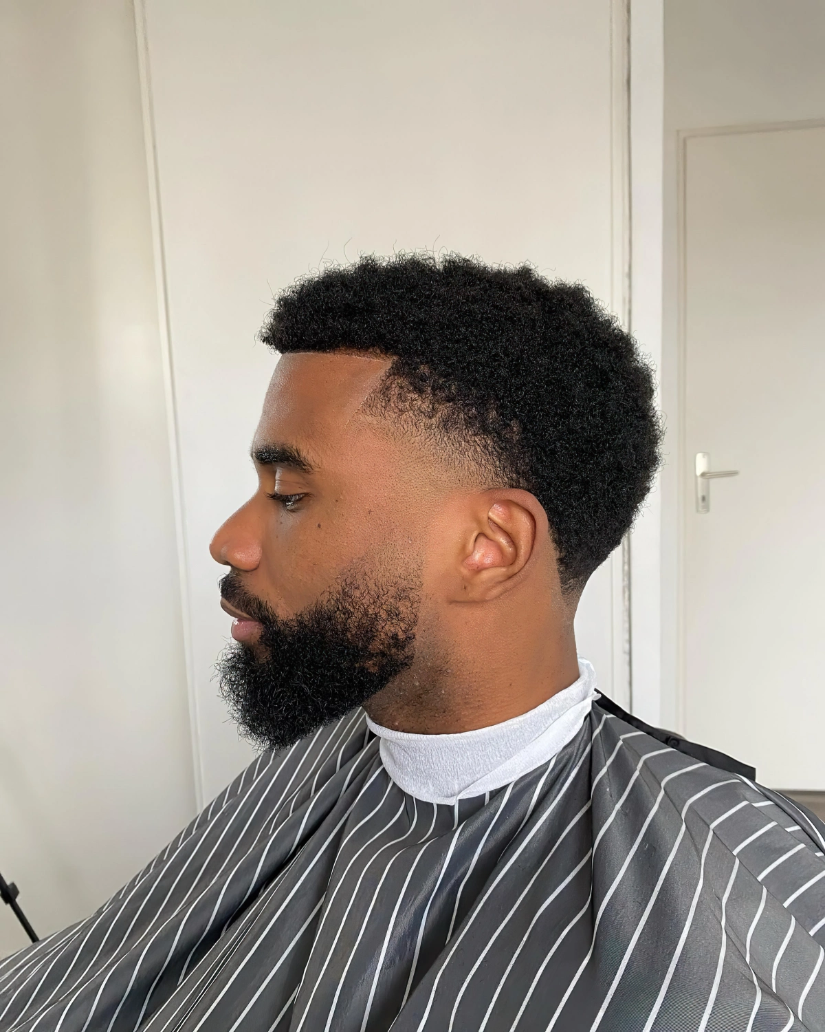 taper coiffure homme barbre arc derriere oreille cheveux frises