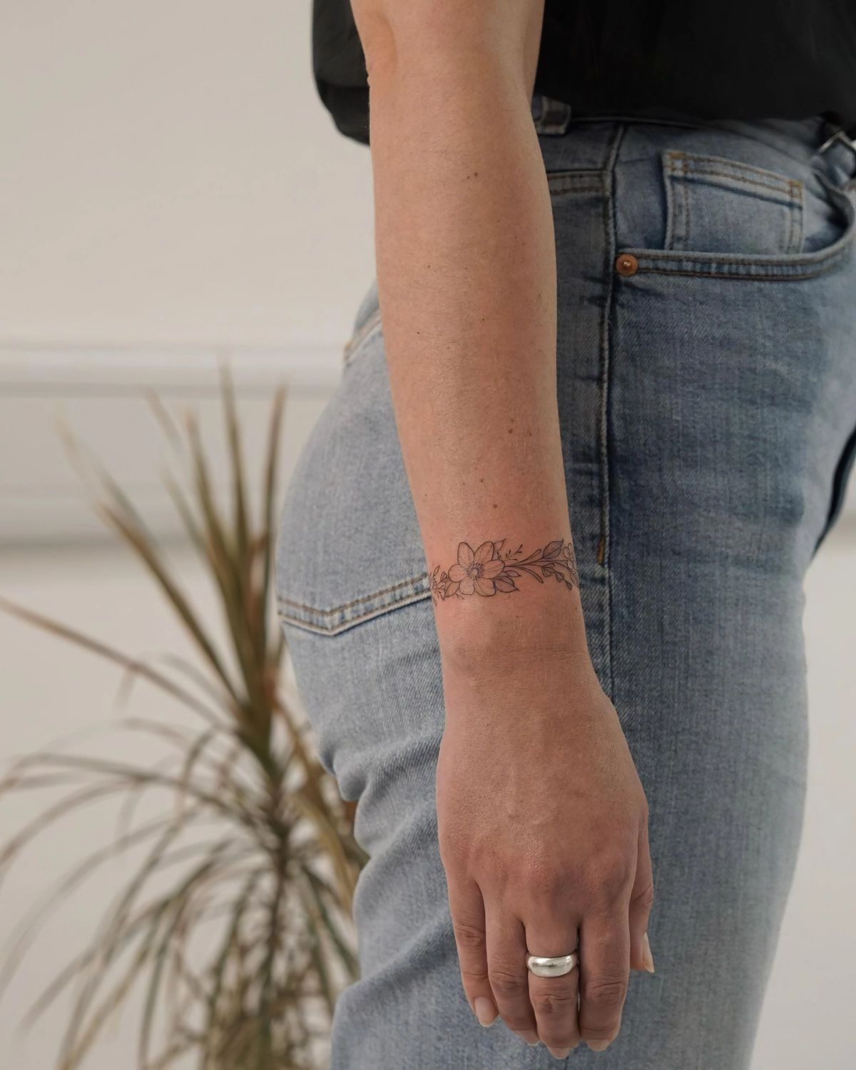 tatouage bracelet femme motifs fleurs bague jeans t shirt noir plante verte