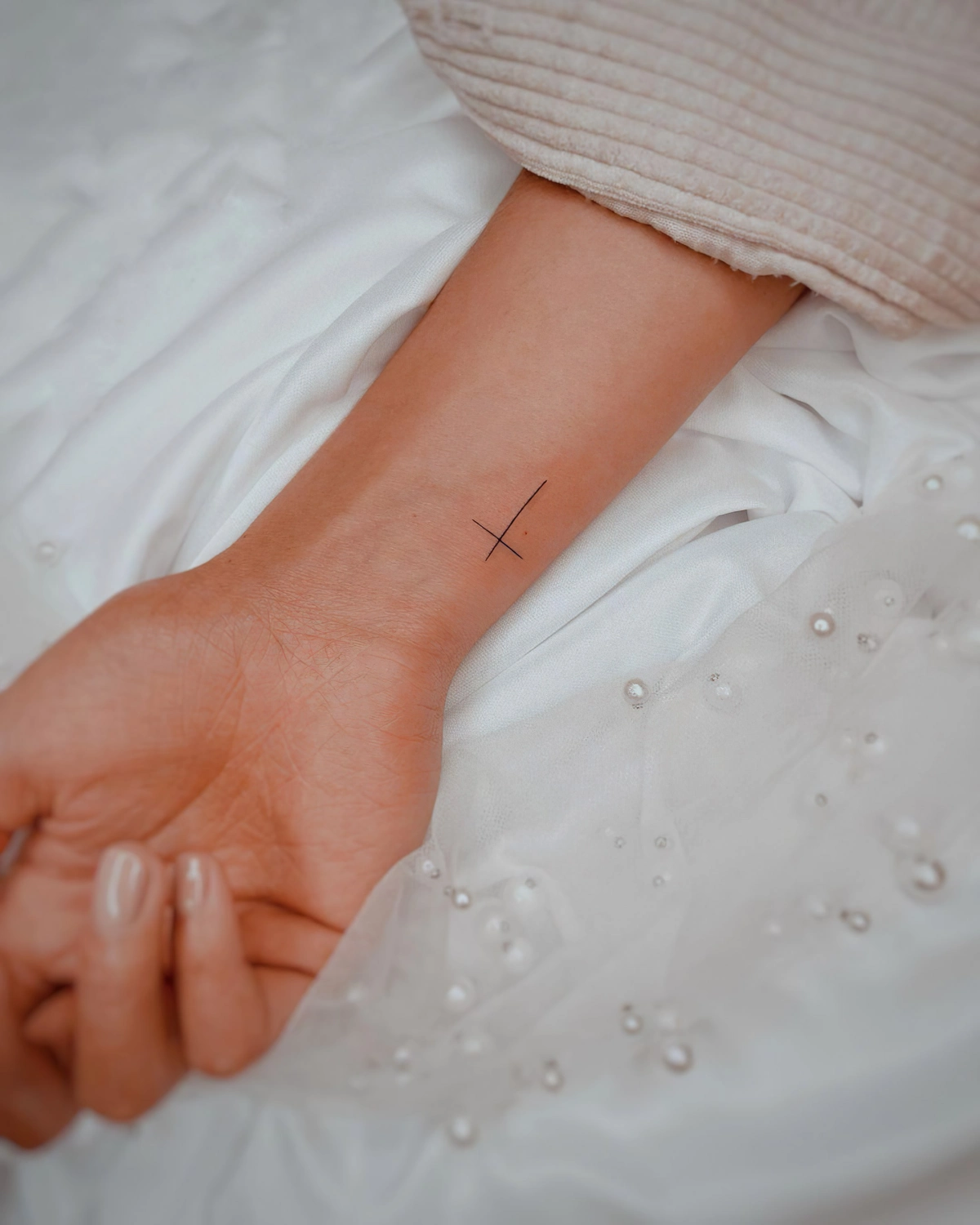 tatouage poignet femme discret croix minimaliste dessin lignes fines