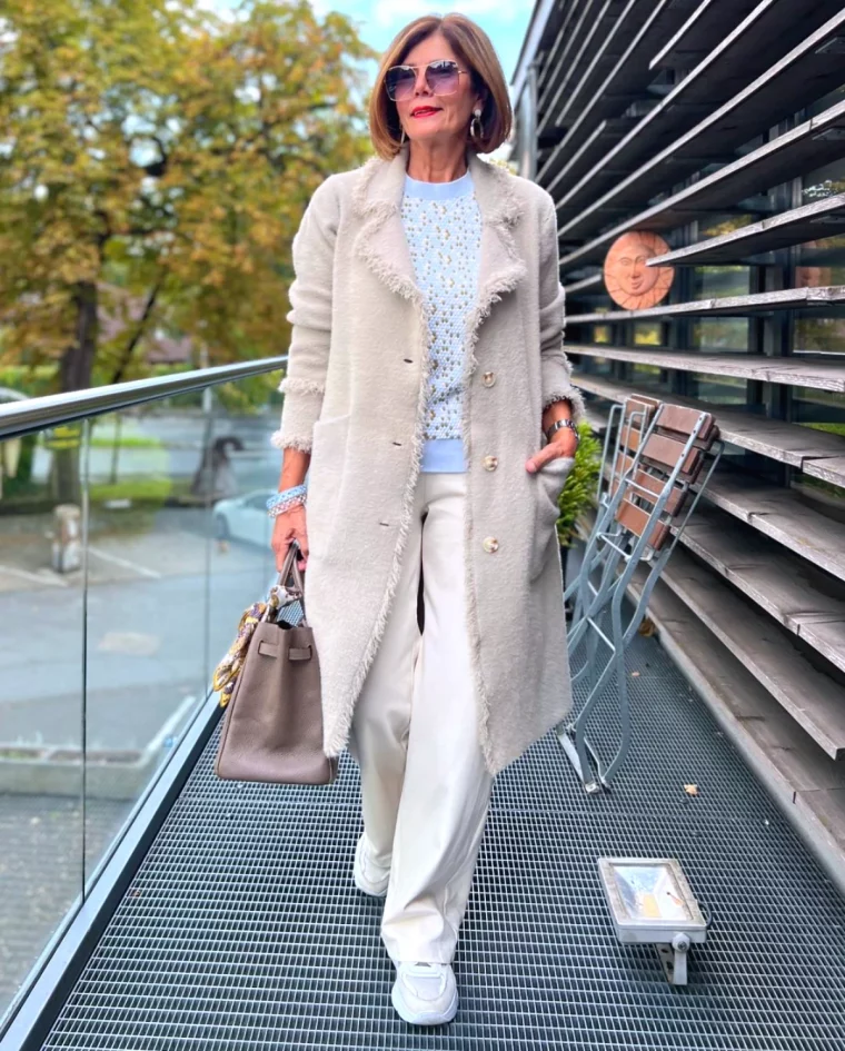 tendance mode femme 60 ans long manteau beige pantalon blanc et baskets blanches