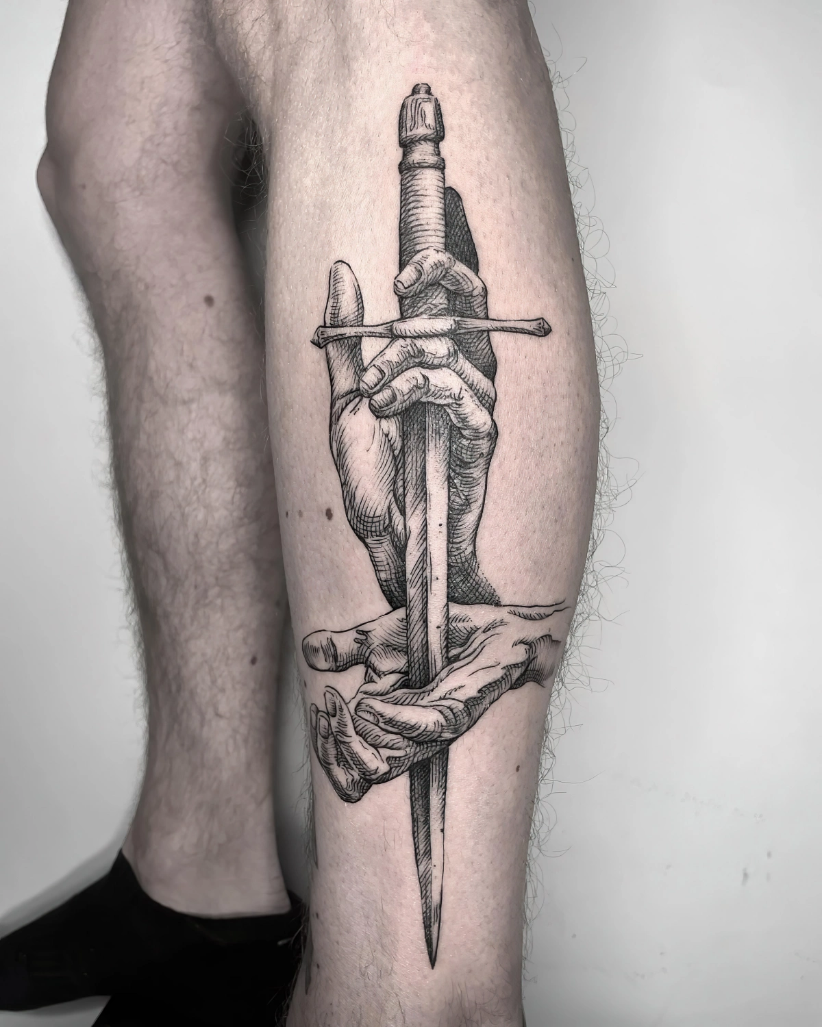 dessin sur jambes hommes motif arme epee mains symbolisme