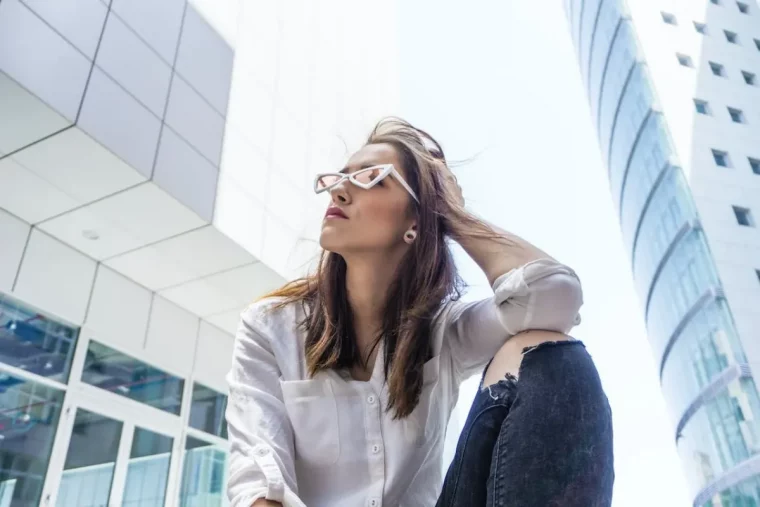 jean bleu dechire chemise blanche et lunettes de soleil