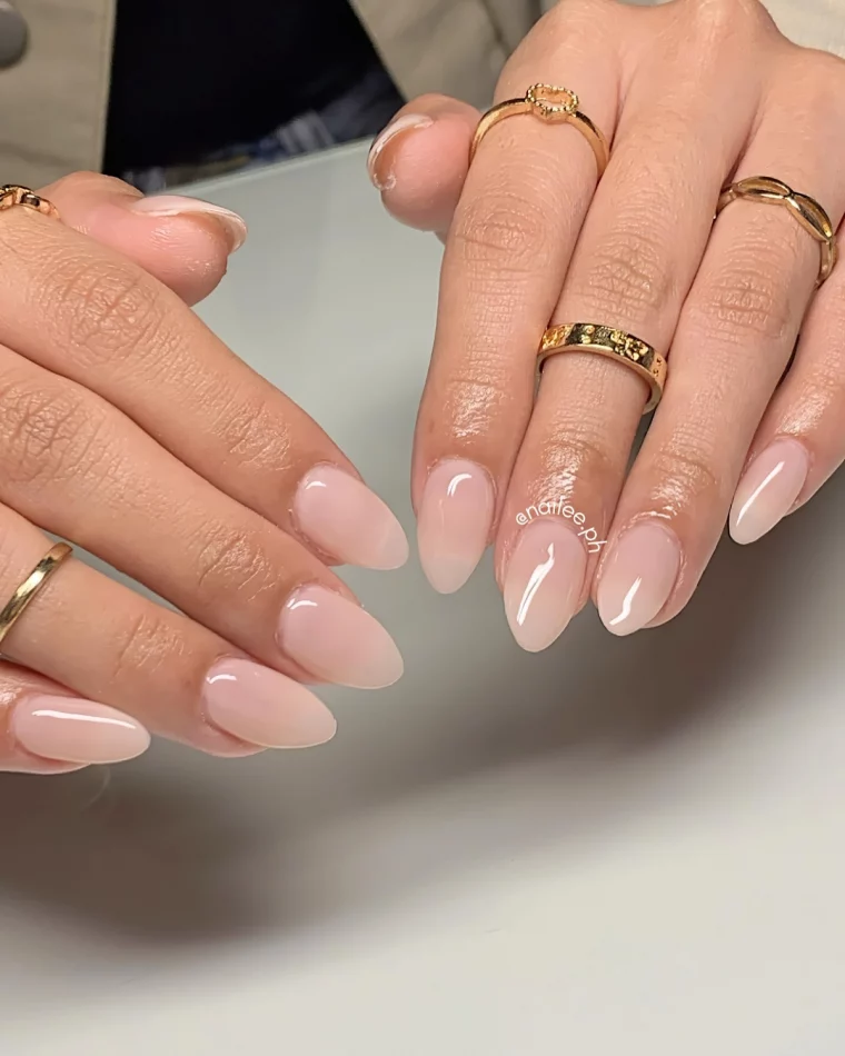 ongles mi longs couleur nude bagues or forme amande mains