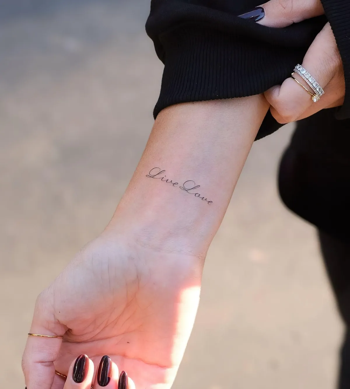 tatouage nom sur le bras d une femme ongles noir et chemise noire