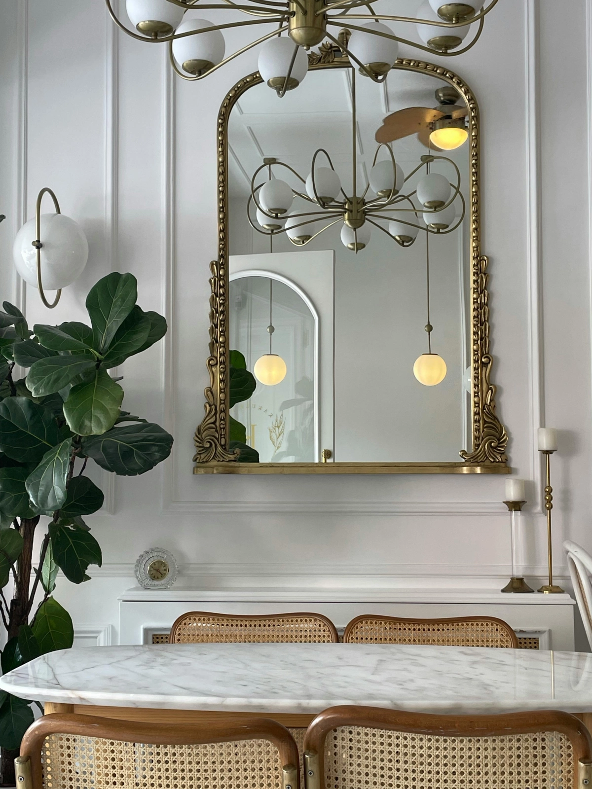 miroir cadre or lustre plante verte table manger marbre blanc chaises rotin