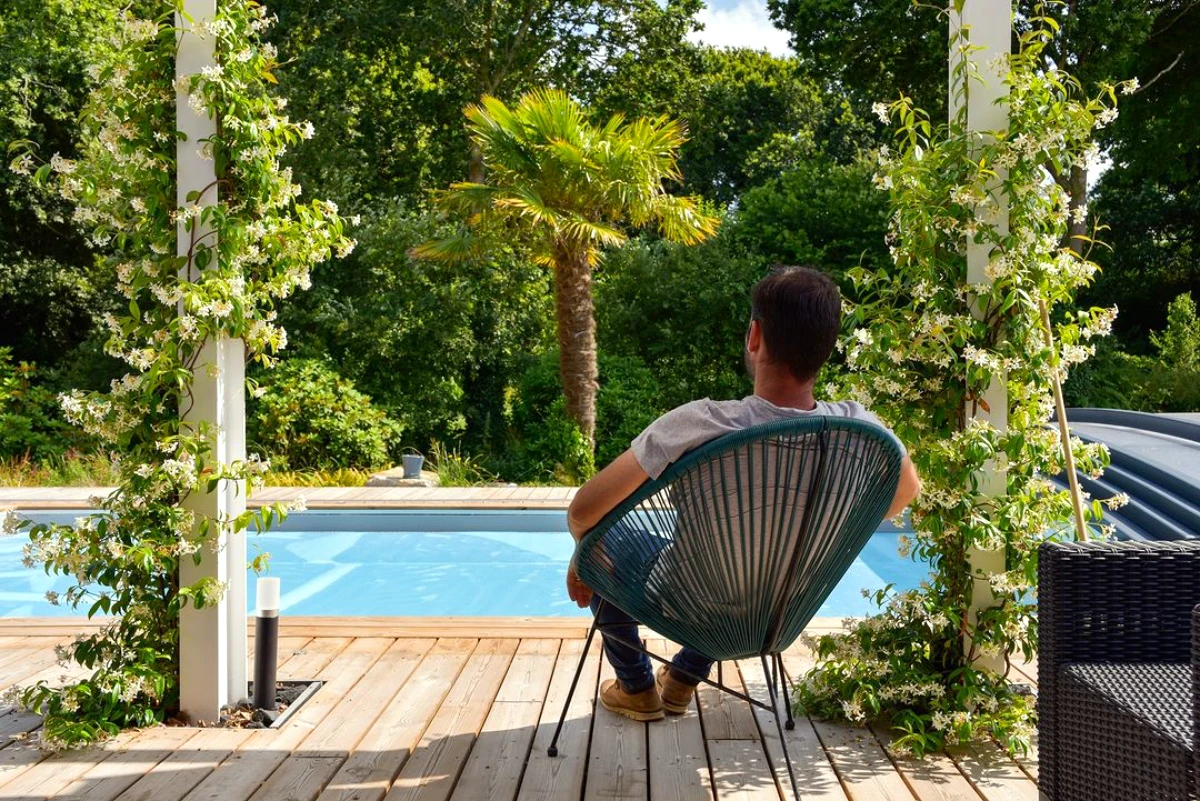 amenagement d'allee devant une piscine avec abris de jardin homme sur une chaise