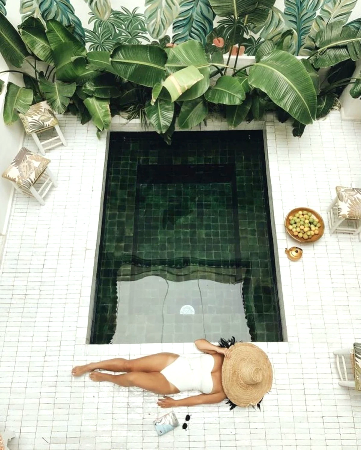 amenagement exotique autour d une piscine creusee plantes vertes femme maillot blanc