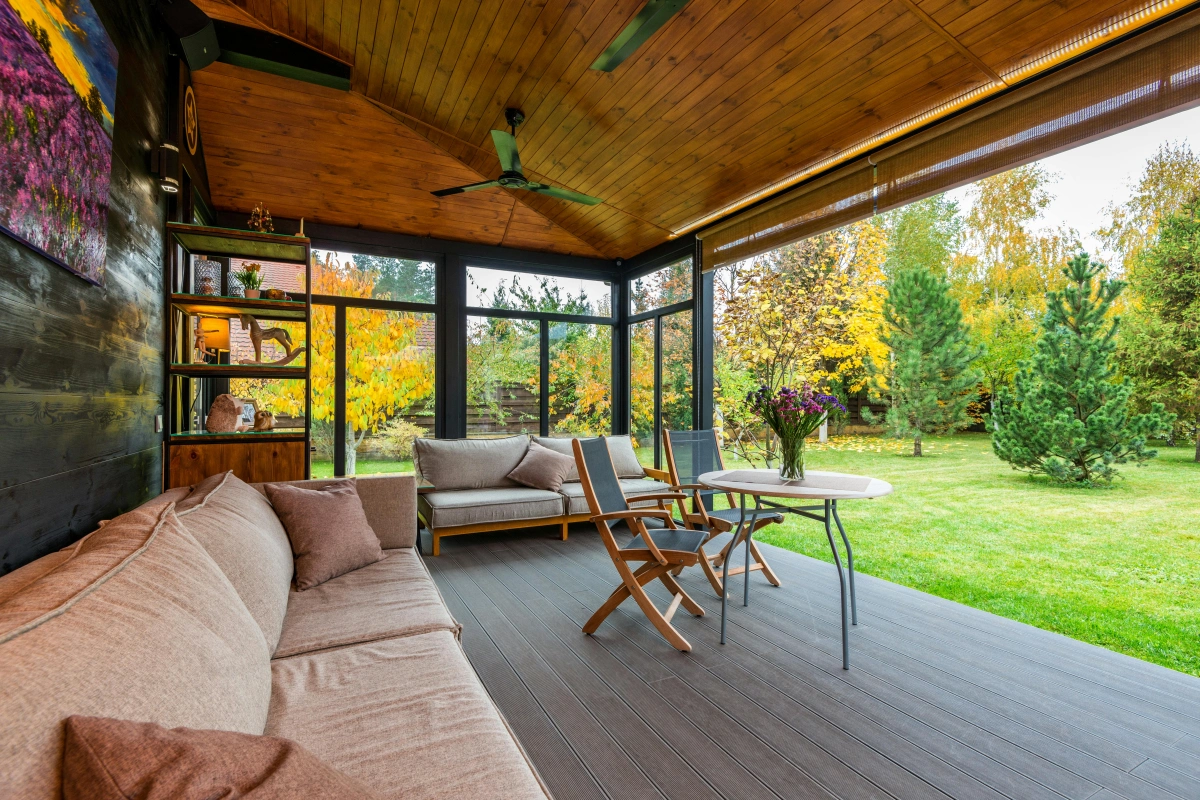 deco extérieure meubles bois terrasse couverte pelouse arbres persistants