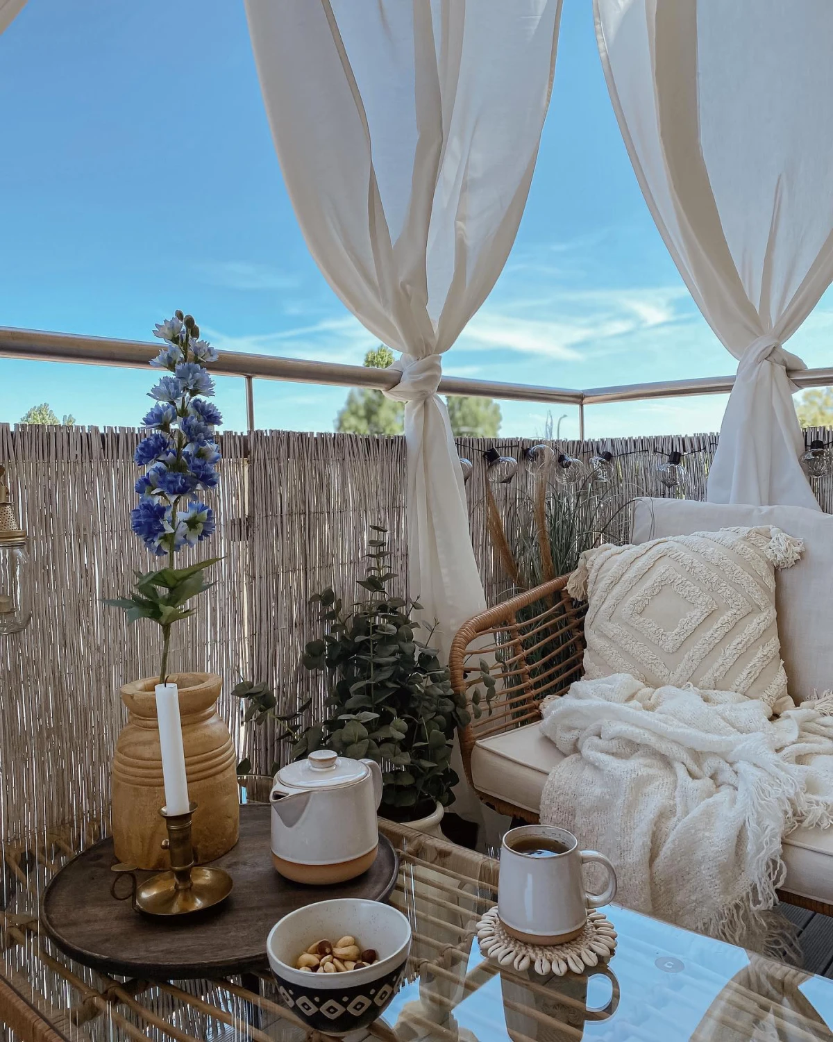 decoration terrasse style boheme chic table en verre canape coussins blancs