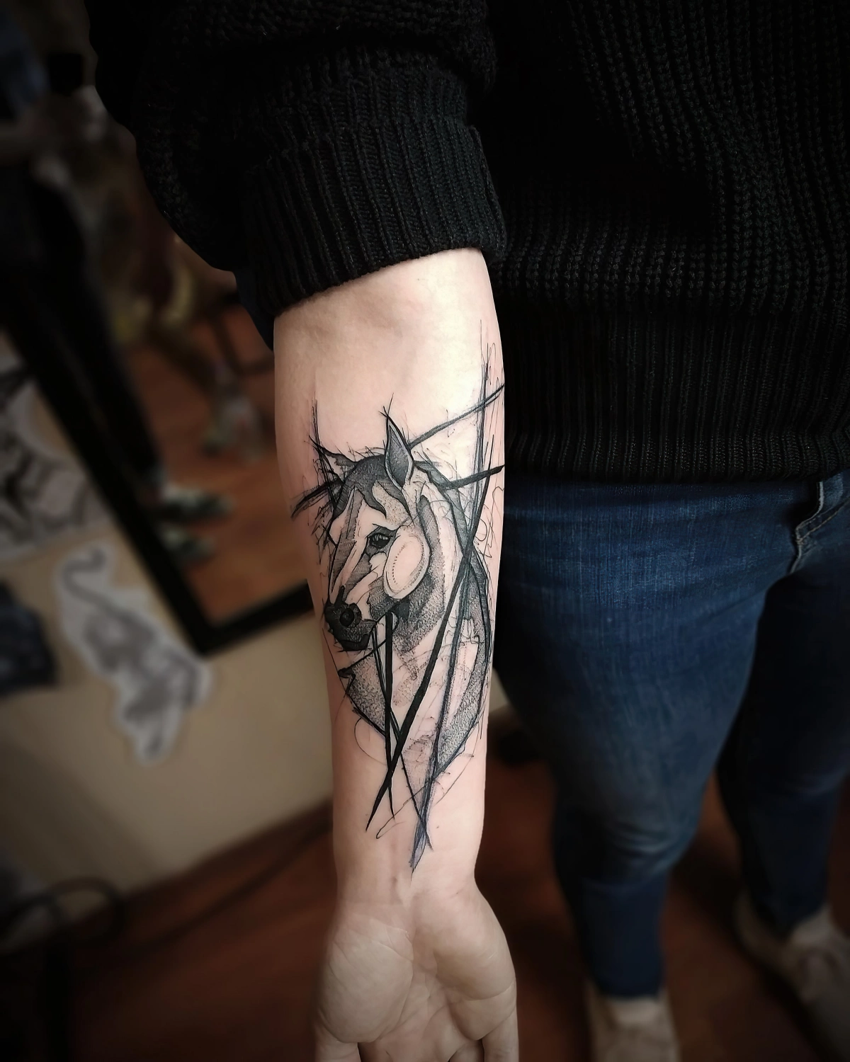 dessin animal sur corps tatouage cheval bras femme pull noir jeans fonces