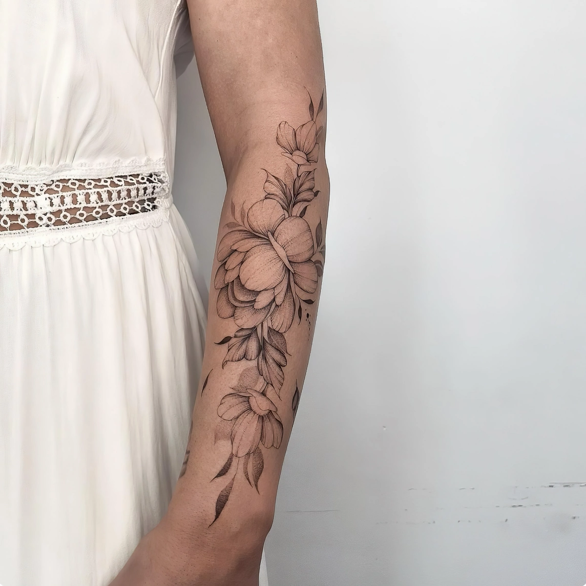 tatouage floral avant bras femme realiste tiges feuilles robe blanche