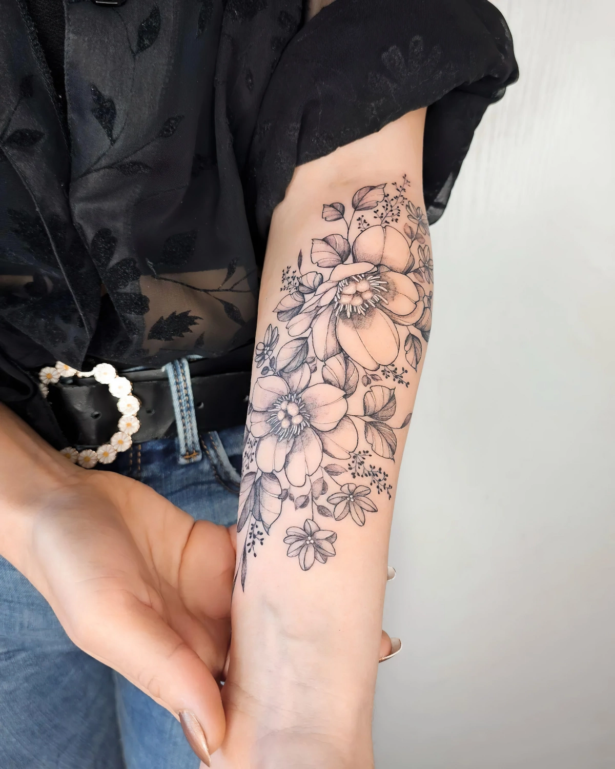tattoo avant bras femme fleurs grandes avec feuilles ceinture jeans