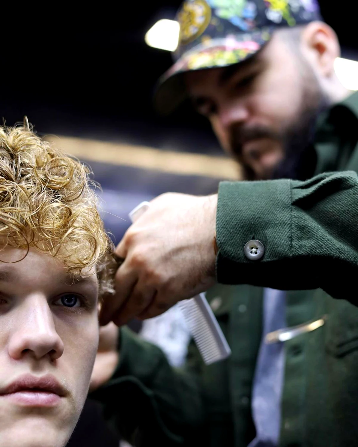 coiffeur qui coupe les cheveux a un garcon blond et boucle