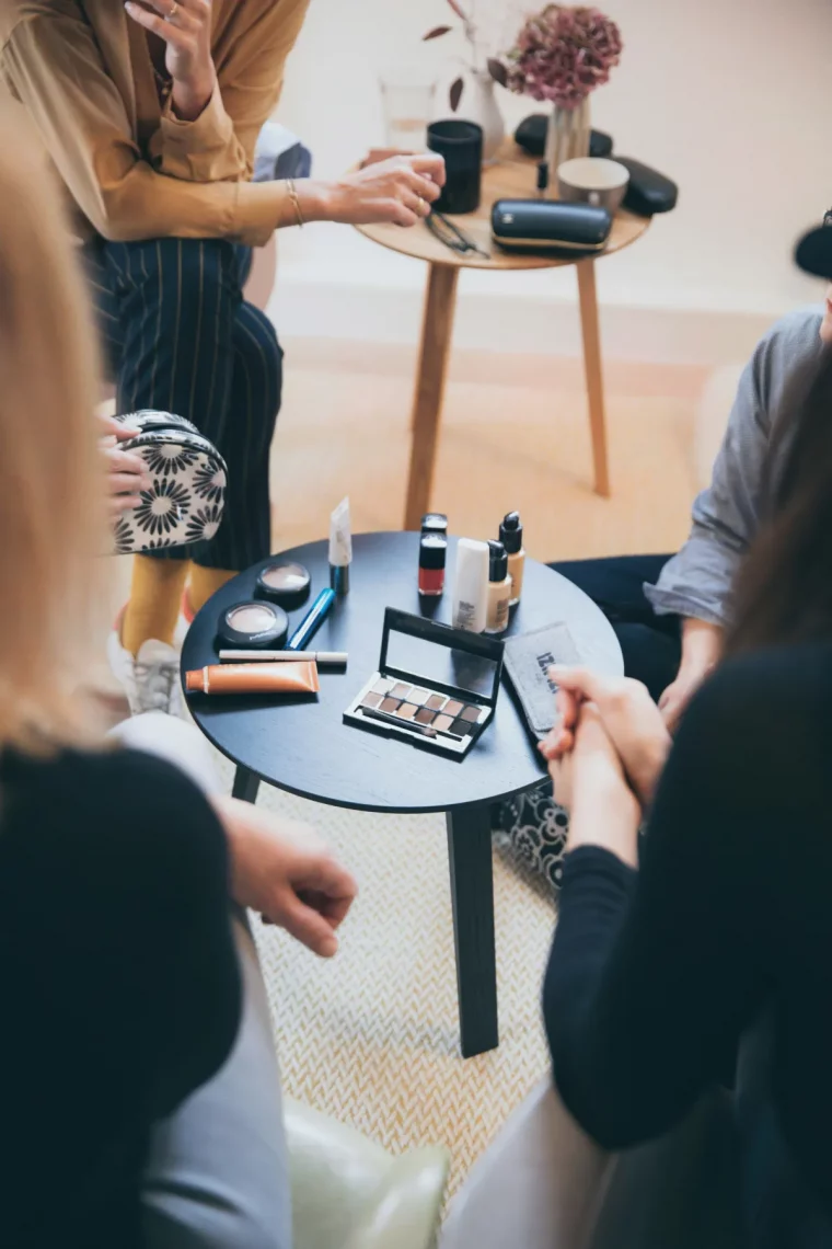 femmes autour d une table remplie de produits de beaute