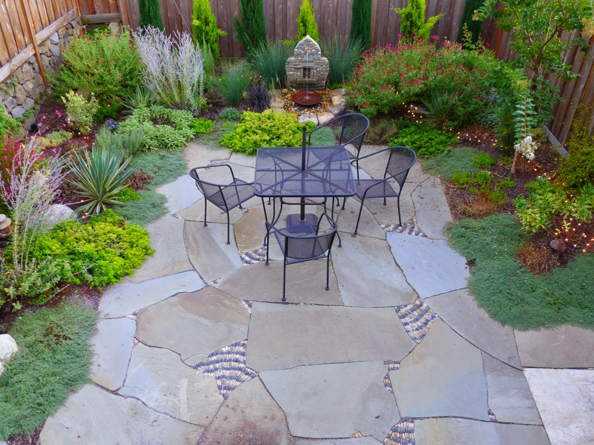 je ne veux plus de pelouse jardin avec grosses dalles et massif de fleurs table chaises