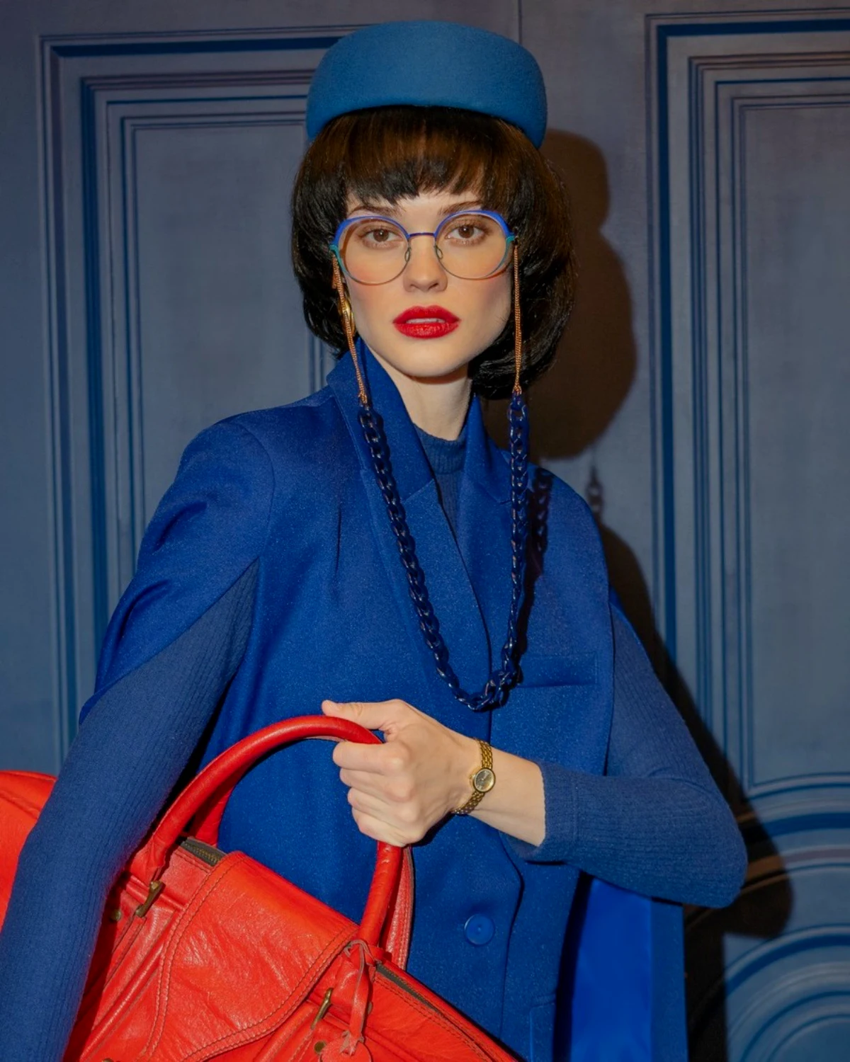 modele femme tenue bleu lunettes bleu sac rouge