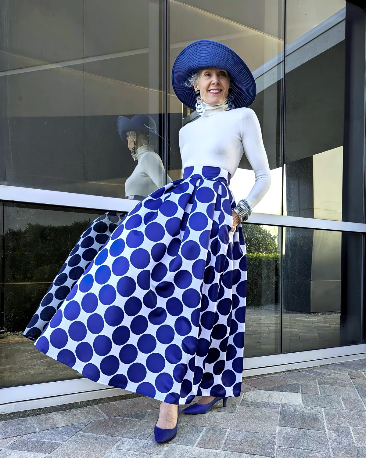 femme de 70 ans tenue sophistiquee avec jupe bleu et chapeau bleu
