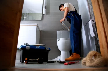 un homme plombier professionnel qui travaille dans les toilettes