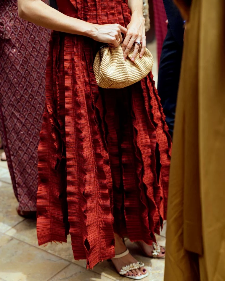 gros plan sur une robe longue volants rouge fonce pochette en osier