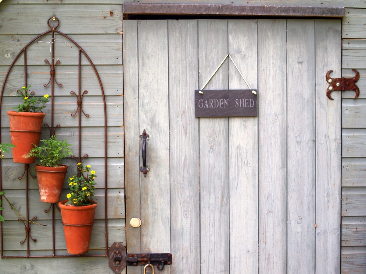 porte abri jardin planches gris bois support pots fleur terre cuite