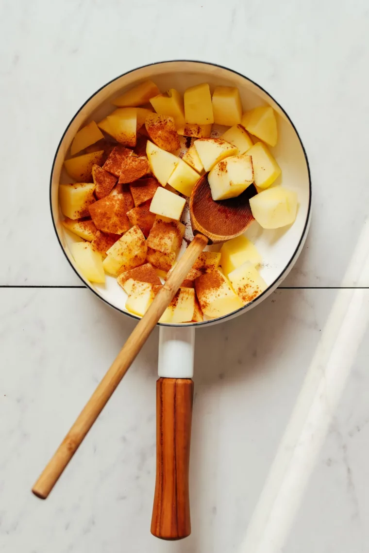 casserole cuillere en bois pommes en morceaux cannelle en poudre