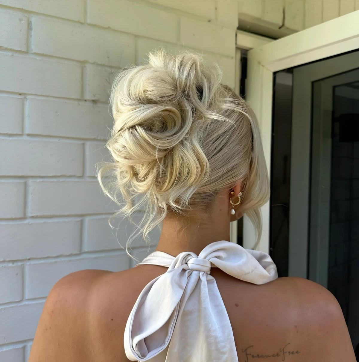 coiffure cheveux attaches chignon haut boucles frange visage