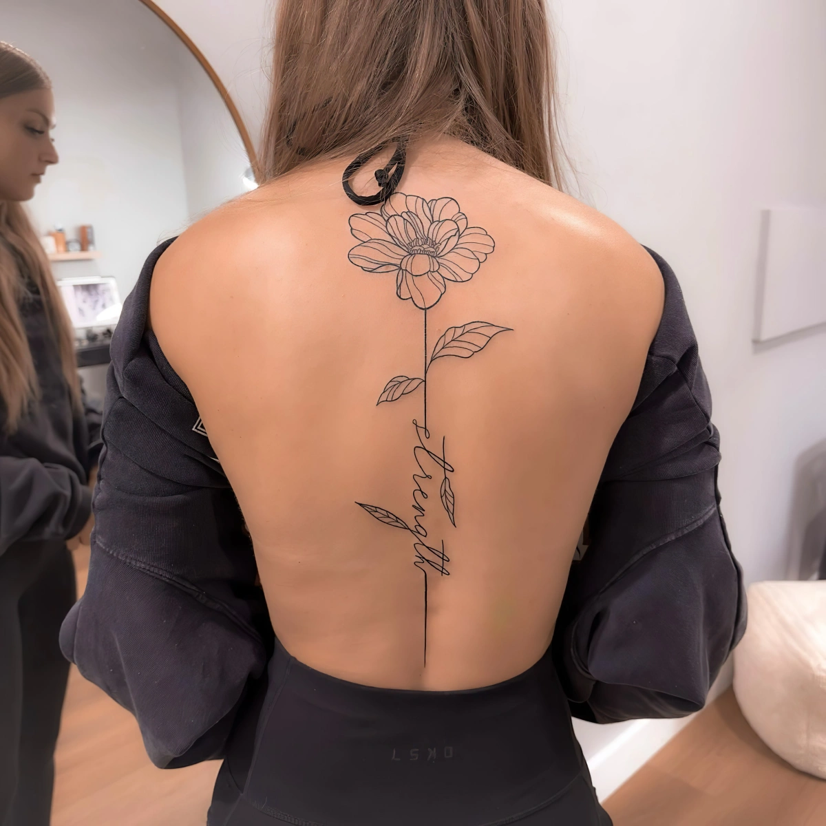 dessin botanique avec lettre phrase tatouage dos femme fleur