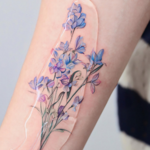 pied d alouette tatouage colore feuilles fleurs bleus violettes