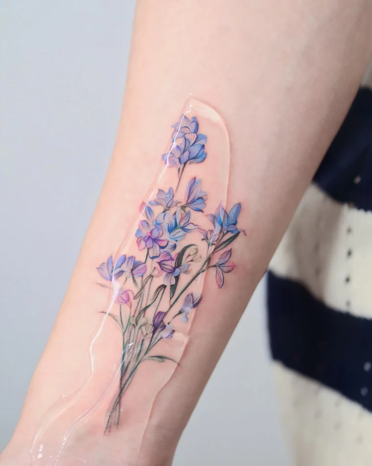 pied d alouette tatouage colore feuilles fleurs bleus violettes