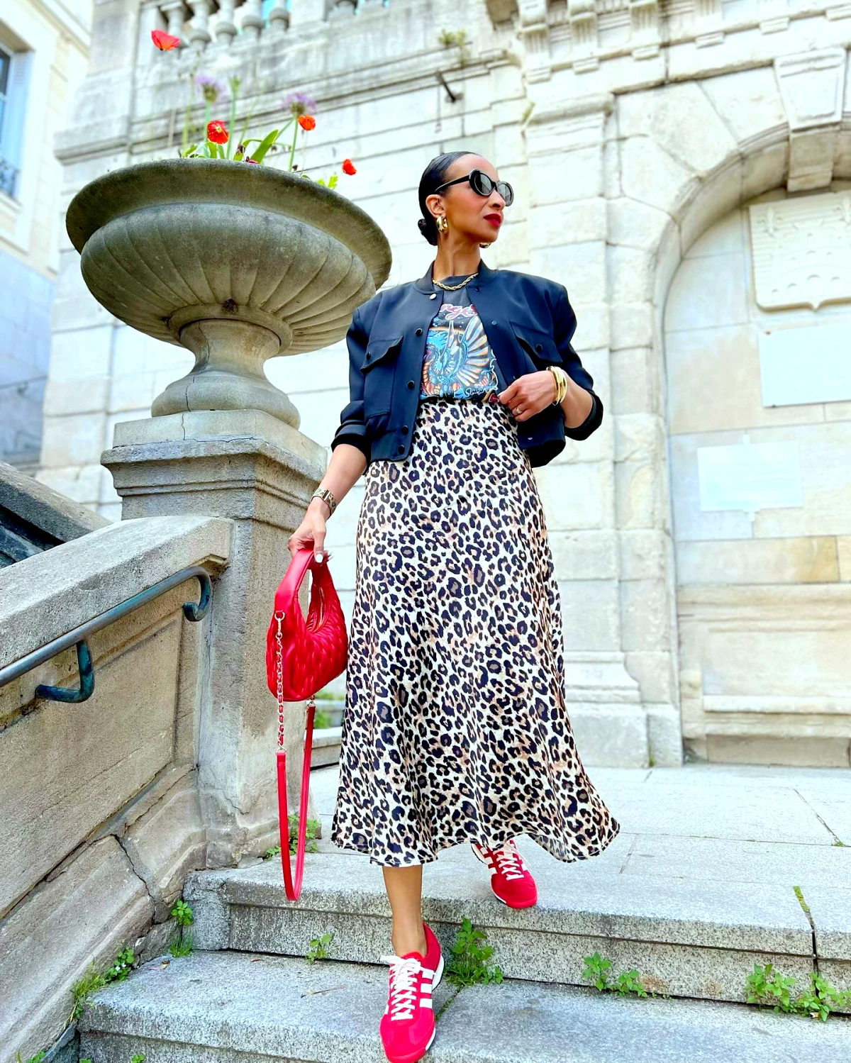 veste courte tendance look moderne jupe en leopard avec un sac rouge