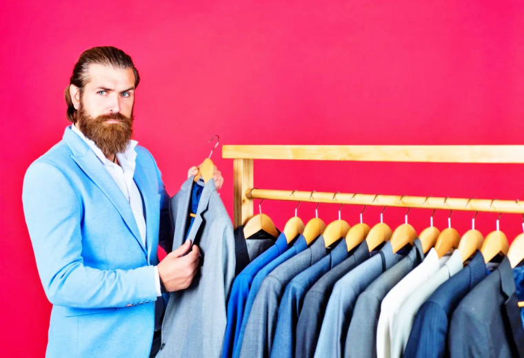 homme avec barbe qui choisi des veste costume