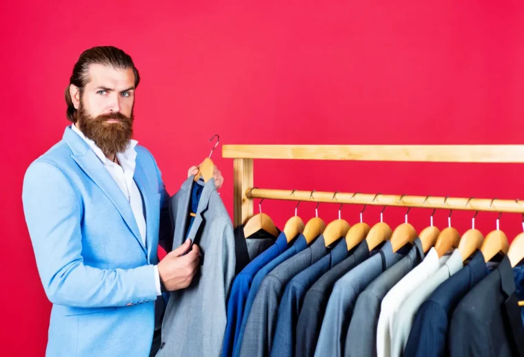 homme avec barbe qui choisi des veste costume