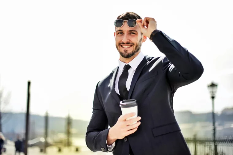 homme en costume elegant qui porte des lunettes de soleil