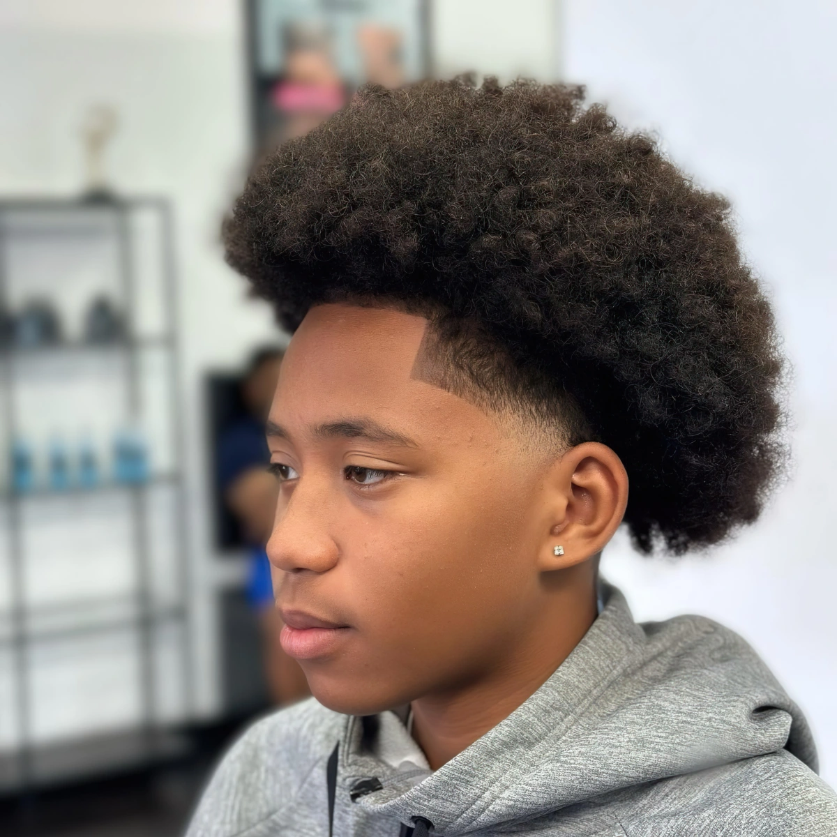 taper bas afro cheveux frises volume dessus piercing oreille homme