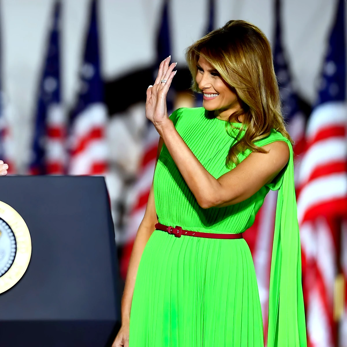 melania trump avec une robe longue plisse vert fluo