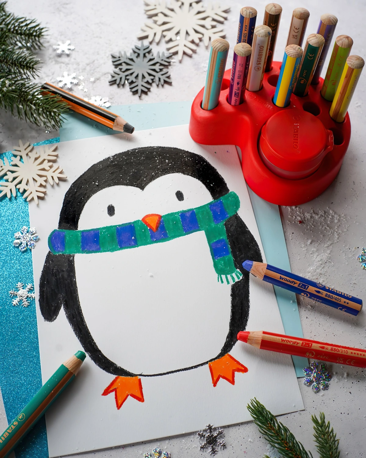 dessin de noel couleur pingouin echarpe vert bleu franges flocons de neige branches sapin surface blanche