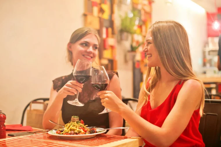 deux filles en train de boire du vin rouge