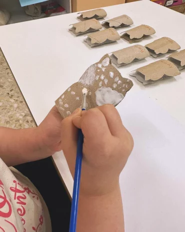 petite fille qui dessine un animal avec des rouleaux du papier toilette