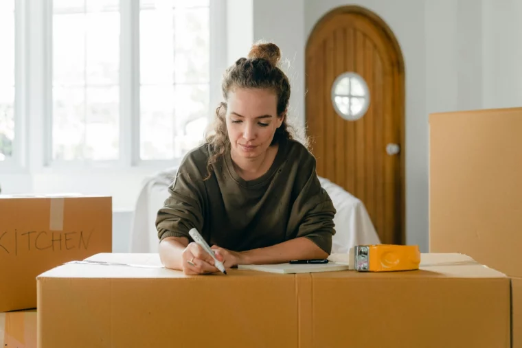 femme etiquettage boites demenagement carton fenetre porte