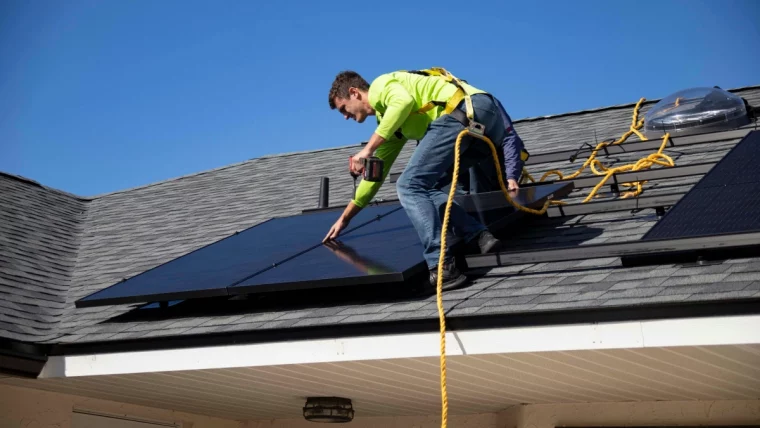 toit maison homme installation panneaux solaires equipement