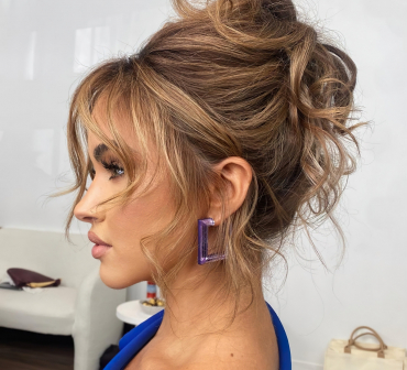 coiffure cheveux boucles avec frange rideau chignon haut messy